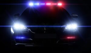 Image of a dark police car with all lights activated.